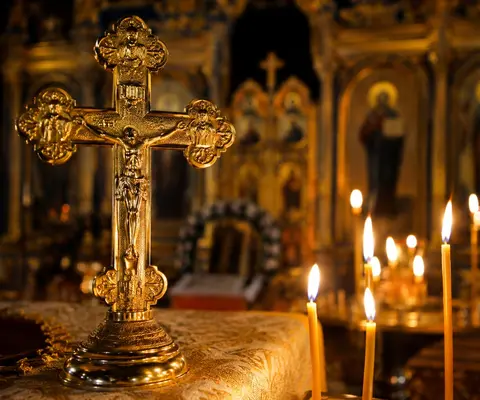 Светият кръст в православен храм със запалени свещи по случай Кръстовден